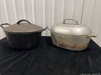 Cast iron Dutch oven and aluminum roaster with lids, full lot overview