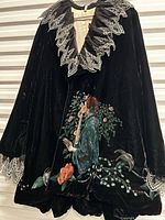 Full view of cloak front on hanger showing artwork and embroidered collar/cuffs