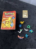 Book, gold-plated card and figurines group shot