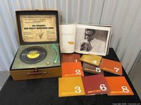 Open case showing faux turntable, book, and CD sleeves 1-7