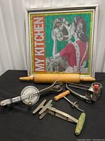 Group shot of framed sign and five kitchen tools