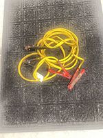 Full view of coiled yellow booster cables with clamps