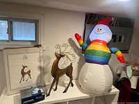Lot overview showing inflatable snowman, metal reindeer, boxed lights