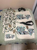 Overview of all five canvas items laid out: two Canada map totes, two whale print totes, one Canada map pouch