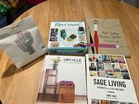 All items laid out: macramé kit box, embroidery kit package, three hardcover books