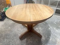 Full view of dining table assembled showing pedestal base and round top