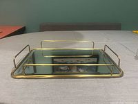 Top view of rectangular mirror tray, gold frame and rail handles visible