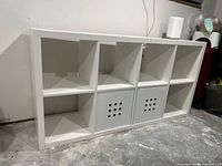 Front view of white IKEA KALLAX 8-cube unit showing two drawer inserts