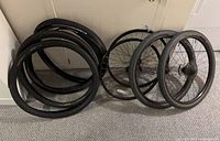 Group of loose tires and wheels leaning against wall