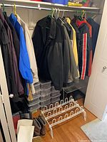Overview of closet with jackets, bins, boots, shoe rack