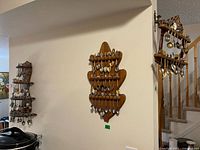 Three wooden spoon racks mounted on walls filled with souvenir spoons