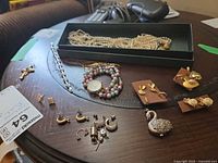 Group shot showing necklace in tray, bracelet, bead watch, pendants and assorted earrings