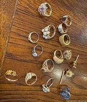 All rings and tie pins laid out on wood surface