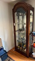 Full view of wood display cabinet with glass door and shelves
