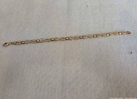 Full view of 10k gold bracelet laid flat showing link pattern and clasp