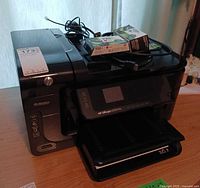 Printer with ink packs and cables on top