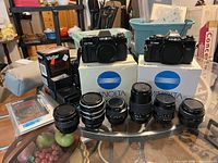 Overall shot: two Minolta camera bodies on boxes, four Minolta lenses, Kiron teleconverter, extension tubes, Vivitar flash