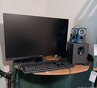 Monitor, keyboard, Logitech speaker system visible together