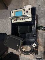 Oscilloscope, two speakers, volt meter and cables in bin