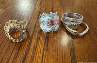 All four sterling rings on wooden surface