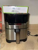Front view of T-fal Easy Fry & Grill air fryer with box of liners on top