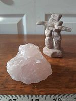 Rose quartz in foreground, stone inukshuk behind, ruler for scale
