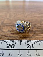 Front view of ring showing logo, stones, size reference