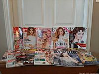Group shot of all fifteen magazines standing and lying on table