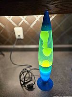 Full view of lava lamp showing blue base, green liquid and yellow wax, cord visible