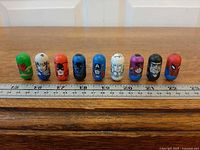 Nine Mighty Beanz lined up with ruler for scale