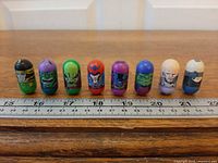 All eight Marvel Mighty Beanz lined up against ruler for scale