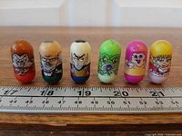 Front view of six Mighty Beanz in a row with ruler for scale