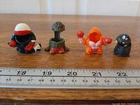 Group shot of the four Mighty Beanz skins with ruler for scale