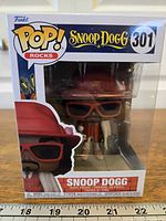 Front view of boxed Funko Pop showing Snoop Dogg figure and #301 labeling