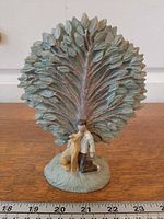 Front view of sculpture showing boy and dog under tree with ruler for scale