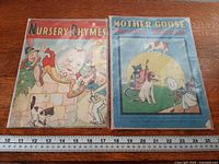 Both nursery rhyme books side by side with ruler for scale