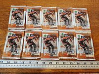 All ten sealed foil packs laid out in two rows with ruler for scale