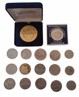 Group shot showing challenge coin in box, wedding crown, and fourteen loose coins/tokens