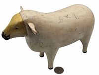 Left side view of carved wooden sheep with coin for scale