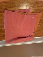 Folded wool throw showing pink side, overall size and fabric texture