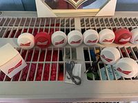 Nine Budweiser Bluetooth speakers, micro-USB cable, small Budweiser box on surface