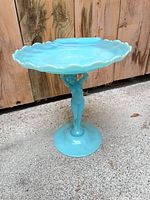 Full view of compote showing scalloped dish, female figure stem, and base