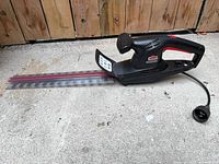 Full view of hedge trimmer showing blade, body and cord