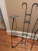 Pedestal stand with square top and scroll easel stand beside it