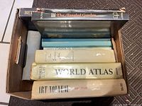 Top view of box showing spines of nine oversized hardcovers