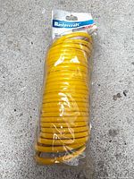Full view of packaged yellow coiled hose