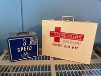 First aid case and lunchbox side by side on shelf