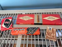 Four boxed game items laid out: UNO deck, dominoes, cribbage board, Paulson deck