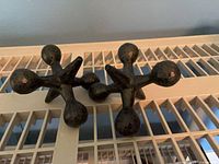 Pair of metal jack sculptures perched on grate