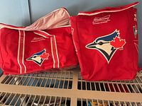 Front view of both red Budweiser x Blue Jays cooler bags